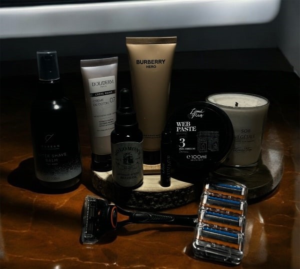 Produits de soins masculins disposés sur un support en marbre brun.